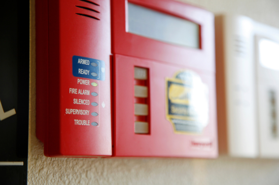 Central de alarme de incêndio em painel vermelho, utilizada para monitorar e sinalizar emergências.