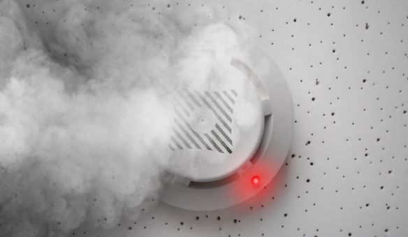 Detector de fumaça identificando presença de fumaça durante teste de manutenção preventiva do sistema de alarme de incêndio.